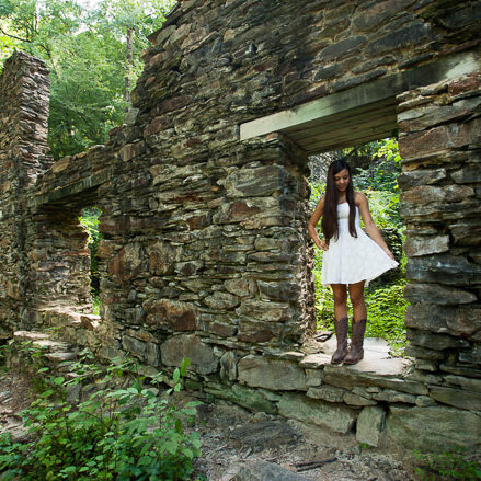 High school senior girl in white dress standing in Sope Creek paper mill ruins