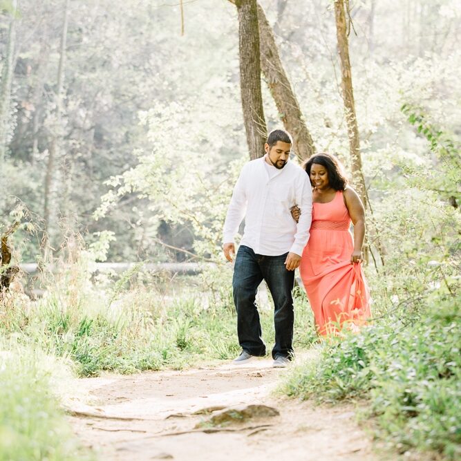 African American engaged couple holding hands and walking a trail next to the Chattahoochee River