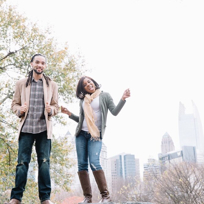 Engaged black couple dancing in the Atlanta skyline at Piedmont Park